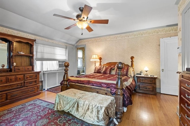 bedroom featuring lofted ceiling, ceiling fan, light wood-style floors, radiator, and wallpapered walls