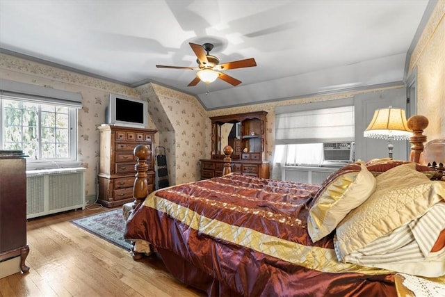 bedroom featuring cooling unit, a ceiling fan, light wood-type flooring, radiator, and wallpapered walls