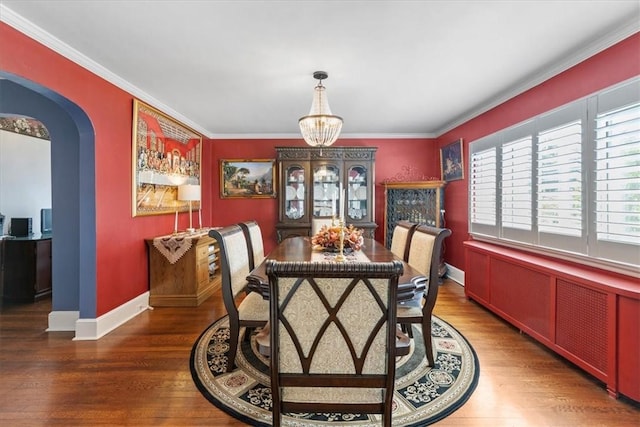 dining room featuring a notable chandelier, crown molding, arched walkways, and wood finished floors