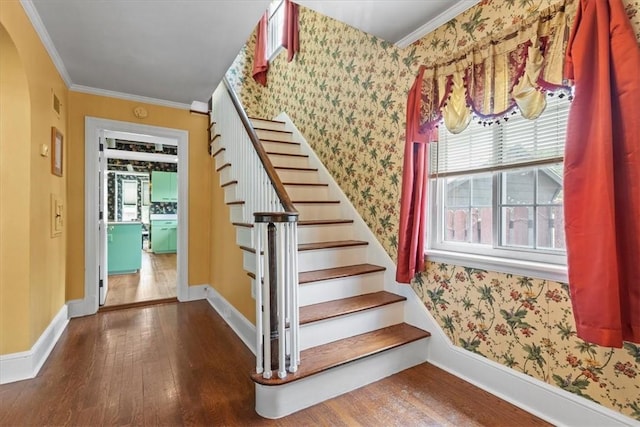 stairway with wallpapered walls, visible vents, baseboards, wood finished floors, and crown molding