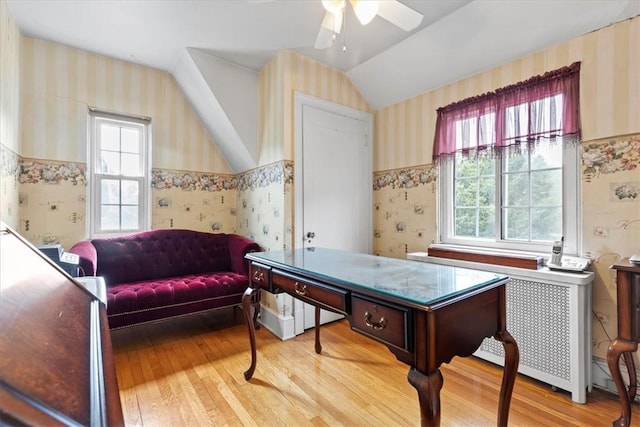 recreation room with lofted ceiling, a ceiling fan, light wood-style floors, radiator, and wallpapered walls