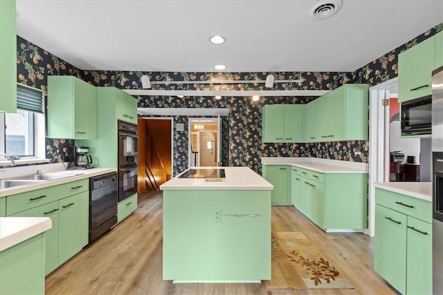 kitchen with light countertops, a kitchen island, and wallpapered walls