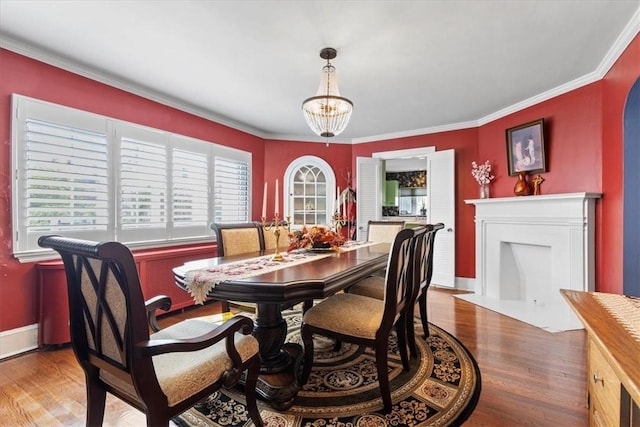 dining area with baseboards, ornamental molding, and wood finished floors