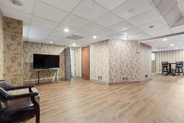 interior space with visible vents, wallpapered walls, and wood finished floors