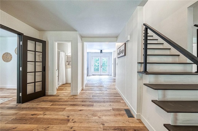 hallway featuring hardwood / wood-style floors and french doors