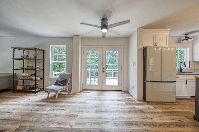 doorway with sink, plenty of natural light, light hardwood / wood-style floors, and french doors