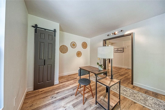 office area featuring a barn door and light hardwood / wood-style floors