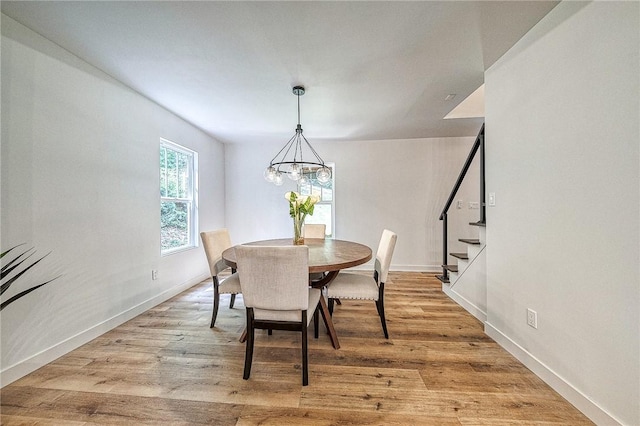 dining space with a notable chandelier and light wood-type flooring