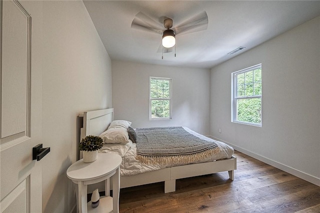 bedroom featuring multiple windows, hardwood / wood-style floors, and ceiling fan