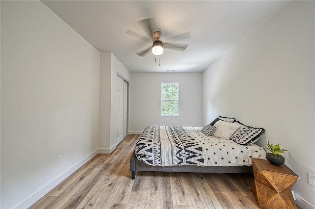 bedroom with light hardwood / wood-style floors, a closet, and ceiling fan