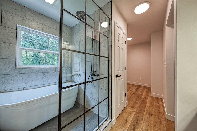 bathroom featuring plus walk in shower and hardwood / wood-style floors