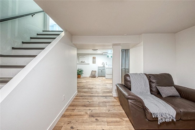 living room featuring separate washer and dryer and light hardwood / wood-style flooring