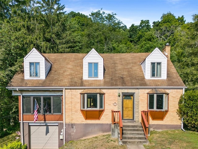 cape cod-style house featuring a garage