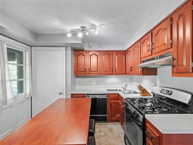 kitchen featuring gas range oven, a textured ceiling, dishwasher, track lighting, and sink