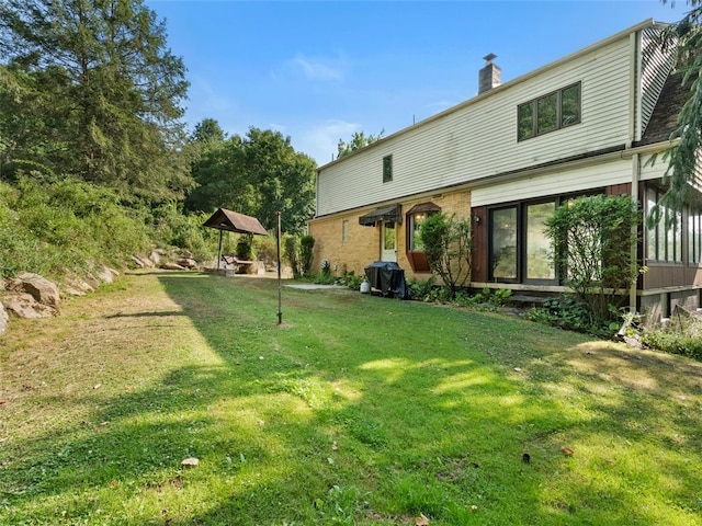 rear view of house featuring a lawn