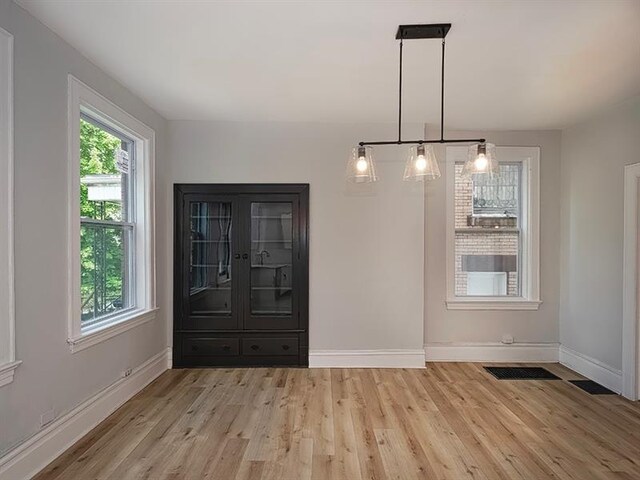 unfurnished dining area with light wood-type flooring