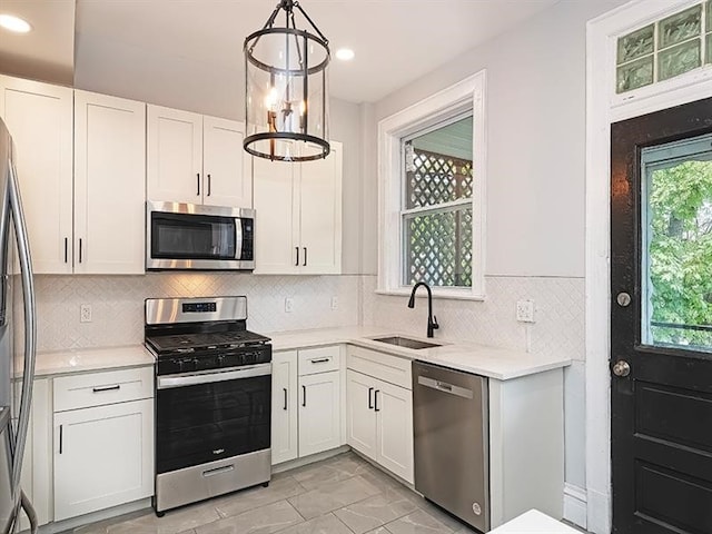 kitchen featuring sink, light tile patterned floors, plenty of natural light, and stainless steel appliances