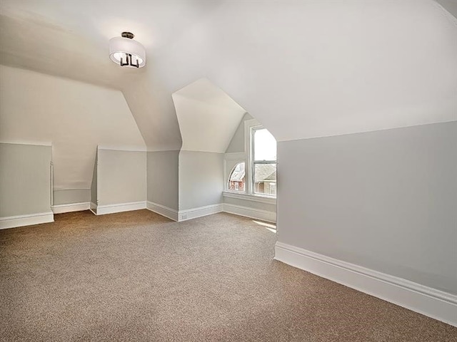 bonus room with lofted ceiling and carpet flooring