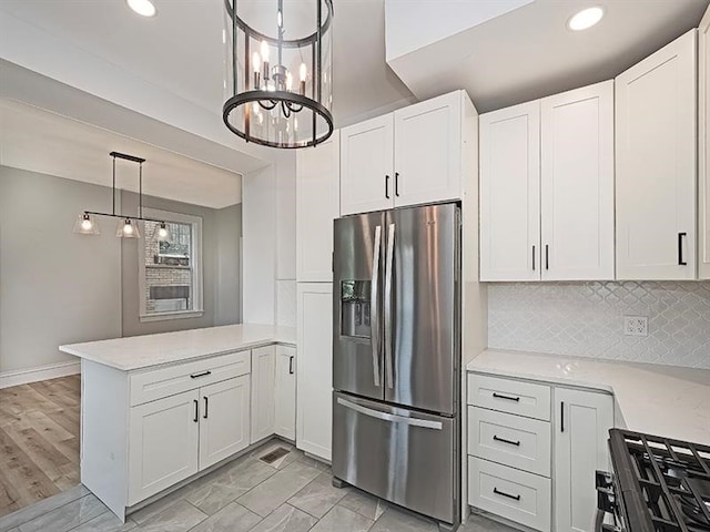 kitchen with tasteful backsplash, stainless steel refrigerator with ice dispenser, white cabinets, light hardwood / wood-style flooring, and kitchen peninsula