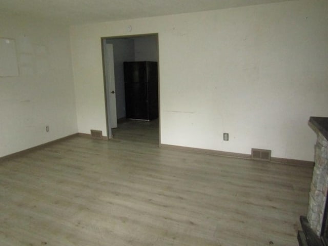 unfurnished room with electric panel and light wood-type flooring