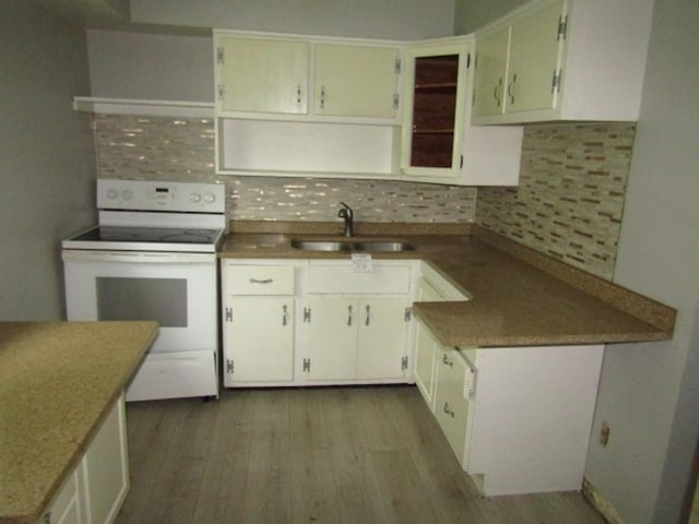 kitchen featuring sink, backsplash, electric stove, light hardwood / wood-style floors, and white cabinets