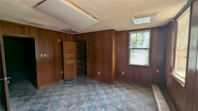 unfurnished bedroom featuring wooden walls