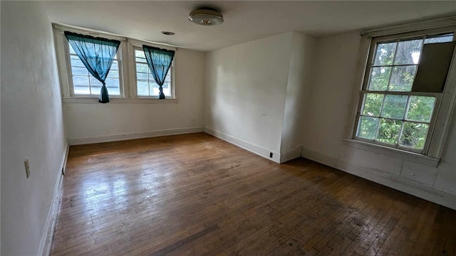 unfurnished room with dark wood-type flooring and plenty of natural light