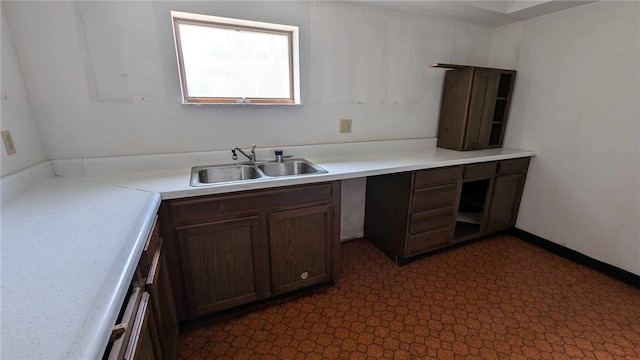 kitchen featuring dark brown cabinets and sink