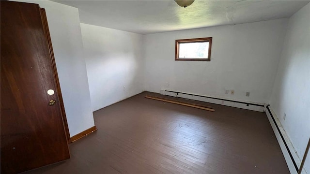 empty room with a baseboard radiator and dark hardwood / wood-style floors