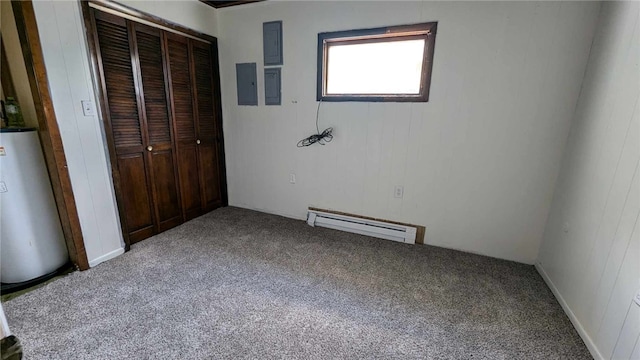 unfurnished bedroom with electric panel, a closet, a baseboard radiator, carpet floors, and water heater