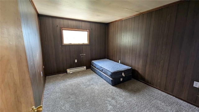 bedroom featuring a baseboard heating unit, crown molding, wooden walls, and carpet floors