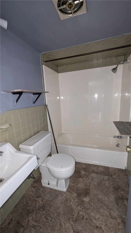 bathroom with tile walls, toilet, and shower / bath combination