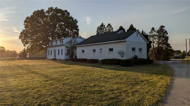 property exterior at dusk with a lawn