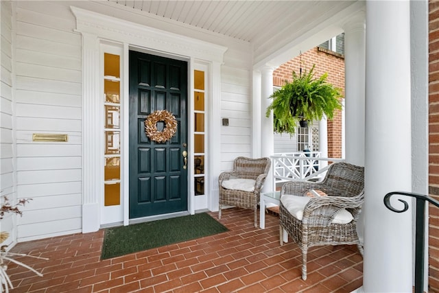 view of exterior entry featuring covered porch