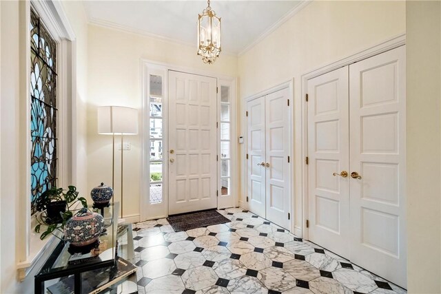 entryway with a notable chandelier and ornamental molding