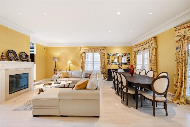 living room with light hardwood / wood-style floors, a fireplace, and ornamental molding