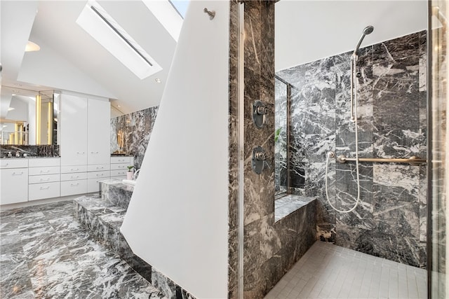 bathroom featuring tile patterned floors, vanity, a shower with door, and lofted ceiling with skylight