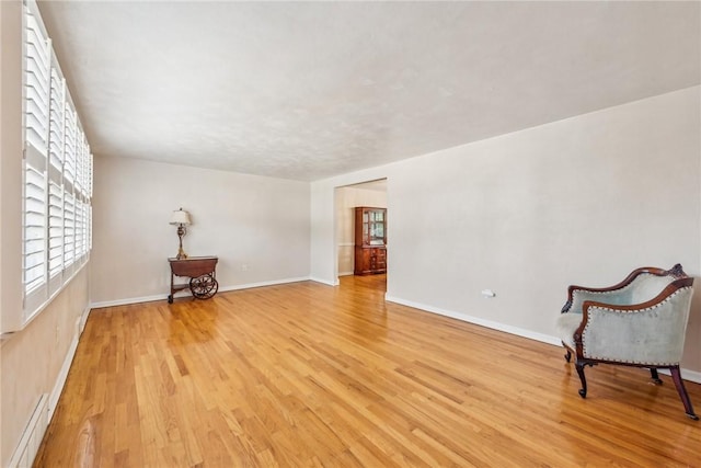 interior space featuring a baseboard radiator and light hardwood / wood-style flooring