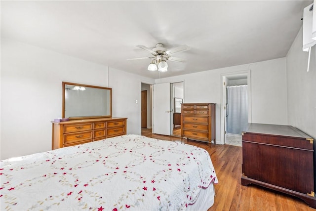 bedroom with ceiling fan, wood-type flooring, connected bathroom, and a closet