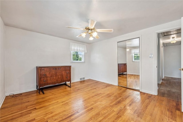 bedroom featuring multiple windows, ceiling fan, light hardwood / wood-style floors, and a closet