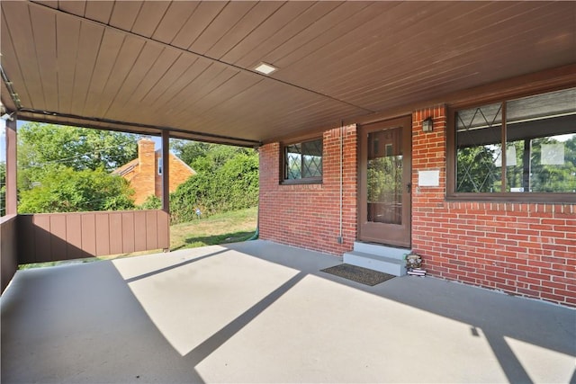 unfurnished sunroom with a wealth of natural light and wooden ceiling