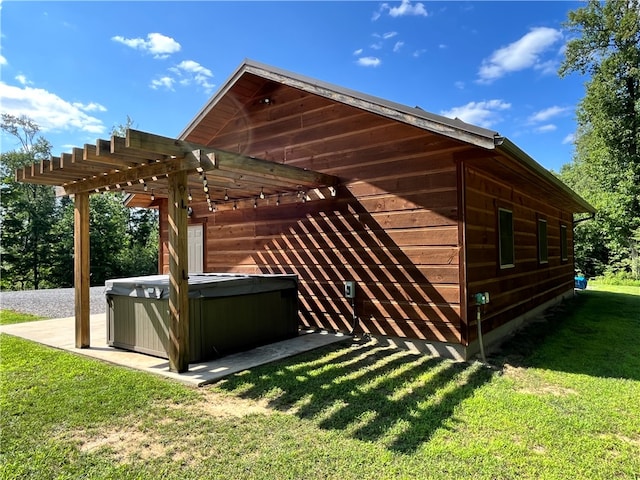 view of home's exterior featuring a pergola, a lawn, and a hot tub