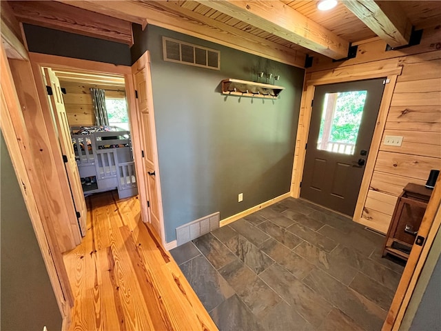 entryway featuring beamed ceiling, dark hardwood / wood-style flooring, wooden walls, and wooden ceiling