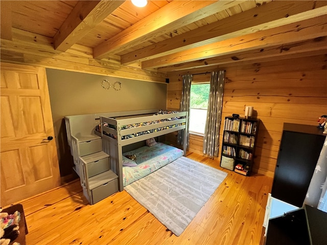 bedroom with light hardwood / wood-style flooring, beam ceiling, wooden walls, and wood ceiling