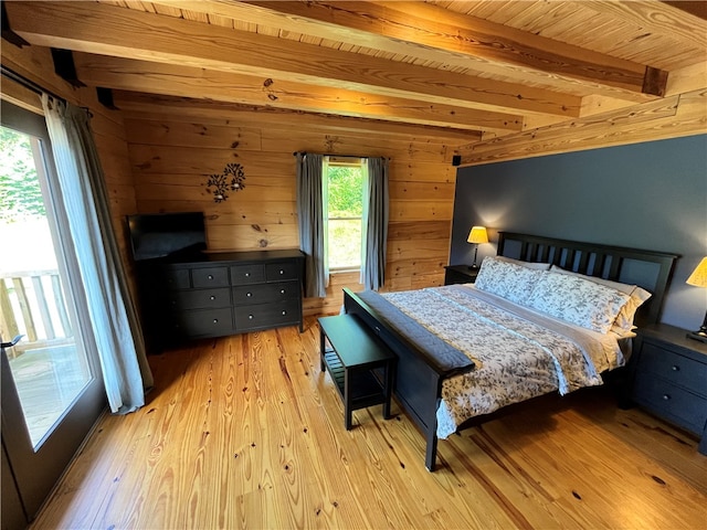 bedroom featuring beamed ceiling, light hardwood / wood-style flooring, and wooden walls