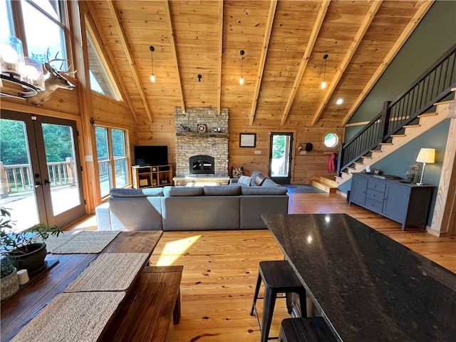 living room featuring wooden walls, french doors, light wood-type flooring, and wood ceiling