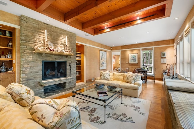 living room featuring wood ceiling, light hardwood / wood-style flooring, beamed ceiling, and a fireplace