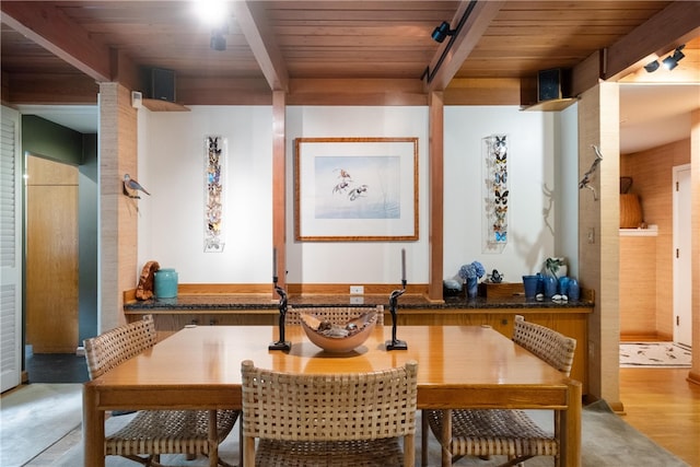 dining area with beam ceiling, light hardwood / wood-style flooring, and wood ceiling