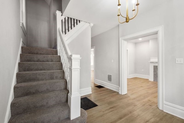 stairs featuring a chandelier and light wood-type flooring