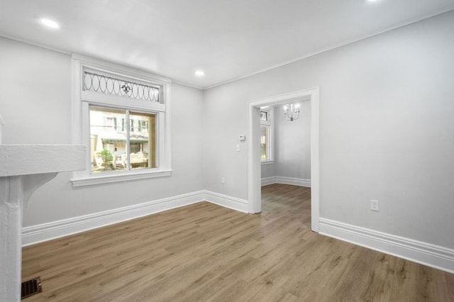 empty room featuring a notable chandelier and hardwood / wood-style floors